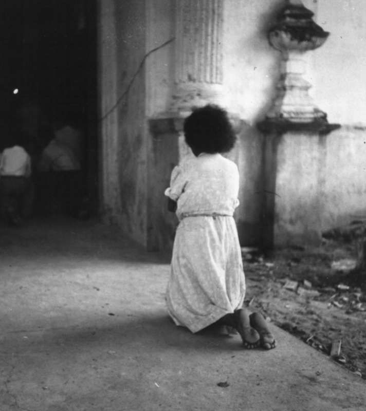 1944 child kneels in church doorway Puerto Rico  